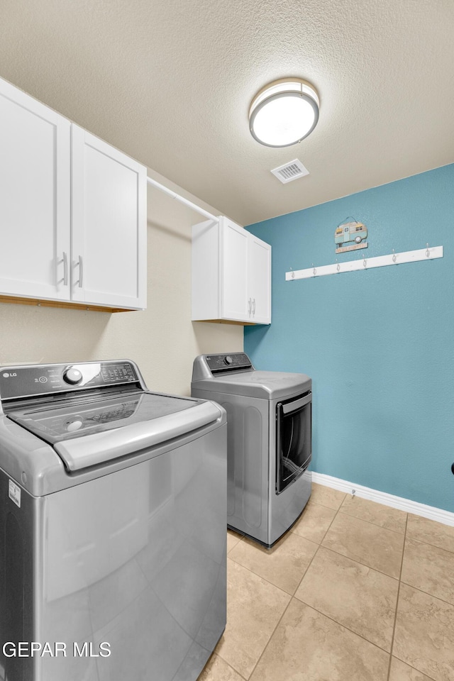 2937 Pino Triste Dr, El Paso, TX 79938 - laundry room featuring washer and clothes dryer, cabinet space, light tile patterned floors, and a textured ceiling