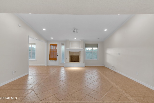 7308 Cerro Negro Dr, El Paso, TX 79912 - unfurnished living room featuring inlaid floor details, recessed lighting, light tile patterned floors, a fireplace with raised hearth, and ornamental molding