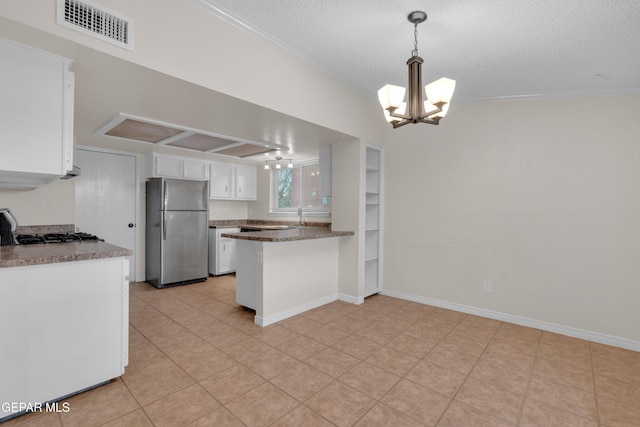 7308 Cerro Negro Dr, El Paso, TX 79912 - kitchen featuring freestanding refrigerator, white cabinetry, a chandelier, a textured ceiling, and ornamental molding