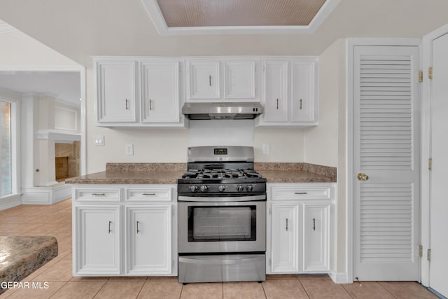 7308 Cerro Negro Dr, El Paso, TX 79912 - kitchen with stainless steel gas range, under cabinet range hood, white cabinets, and light tile patterned flooring