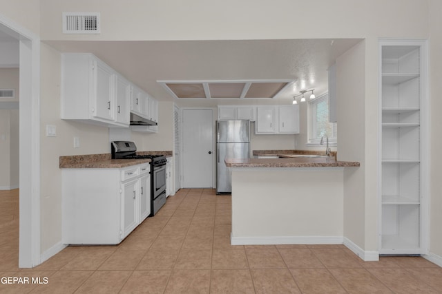 7308 Cerro Negro Dr, El Paso, TX 79912 - kitchen with appliances with stainless steel finishes, under cabinet range hood, white cabinetry, a peninsula, and light tile patterned floors
