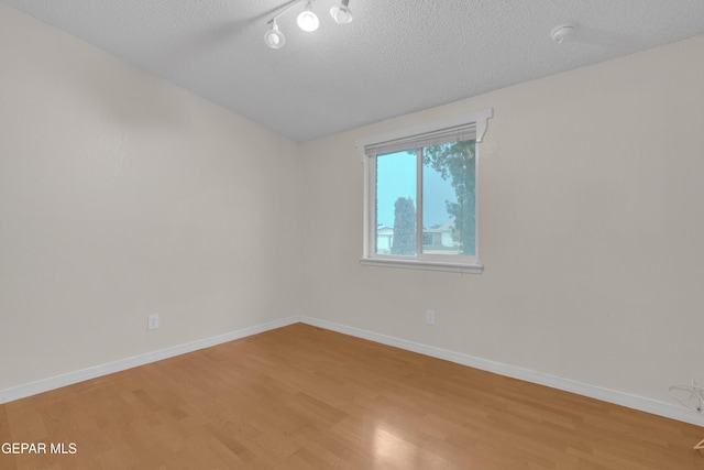 7308 Cerro Negro Dr, El Paso, TX 79912 - spare room featuring light wood-type flooring, a textured ceiling, track lighting, and lofted ceiling