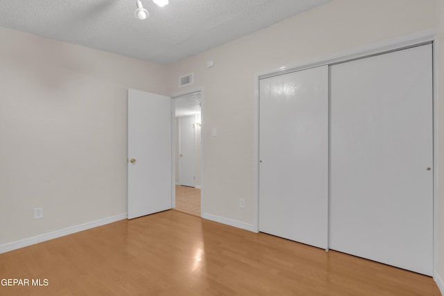 7308 Cerro Negro Dr, El Paso, TX 79912 - unfurnished bedroom featuring light wood-style floors, a closet, and a textured ceiling