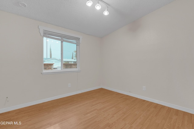 7308 Cerro Negro Dr, El Paso, TX 79912 - empty room featuring light wood-style floors, a textured ceiling, and lofted ceiling