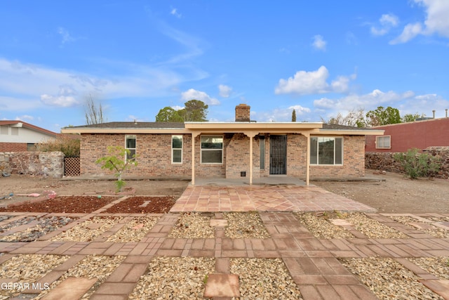 7308 Cerro Negro Dr, El Paso, TX 79912 - rear view of house featuring a patio, brick siding, and a chimney