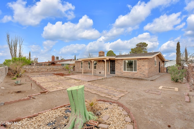 7308 Cerro Negro Dr, El Paso, TX 79912 - back of property featuring a patio, a fenced backyard, a chimney, and brick siding