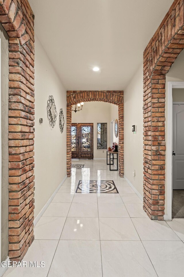 10728 Regina Dr, Socorro, TX 79927 - corridor with light tile patterned floors, arched walkways, recessed lighting, and ornate columns