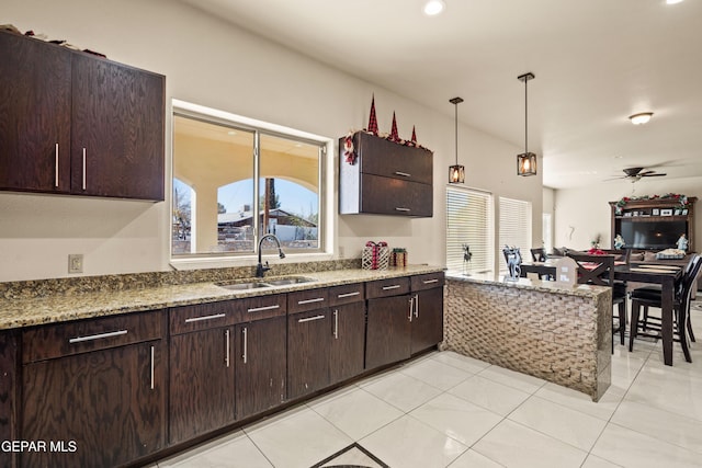 10728 Regina Dr, Socorro, TX 79927 - kitchen featuring a ceiling fan, dark brown cabinetry, light tile patterned floors, and decorative light fixtures