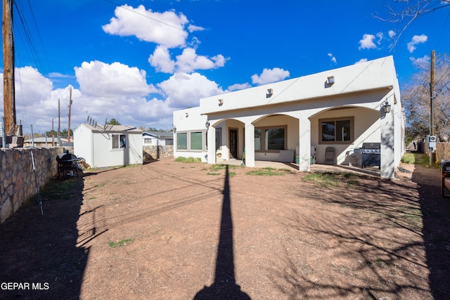 10728 Regina Dr, Socorro, TX 79927 - rear view of house featuring a patio, a storage shed, and stucco siding