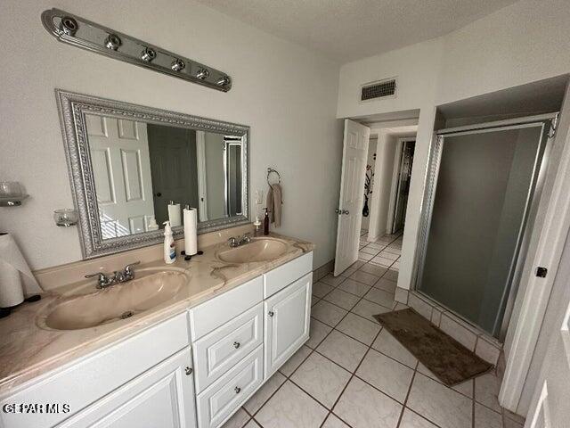 2129 Noviembre Dr, El Paso, TX 79935 - bathroom with double vanity, a shower stall, and tile patterned floors