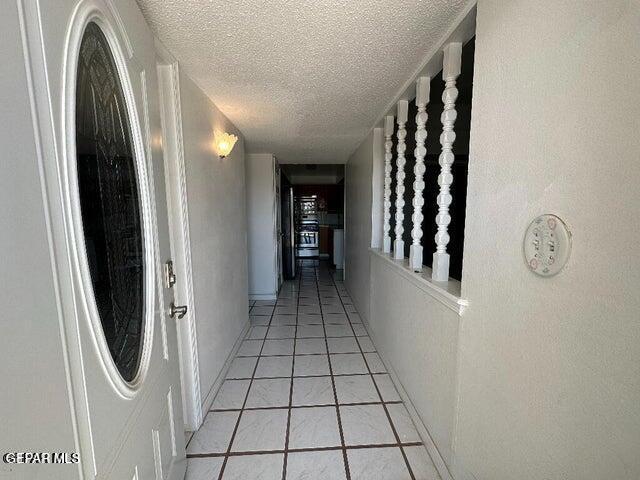 2129 Noviembre Dr, El Paso, TX 79935 - hallway with a textured ceiling and light tile patterned floors