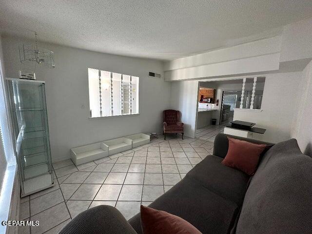 2129 Noviembre Dr, El Paso, TX 79935 - living area with light tile patterned floors and a textured ceiling