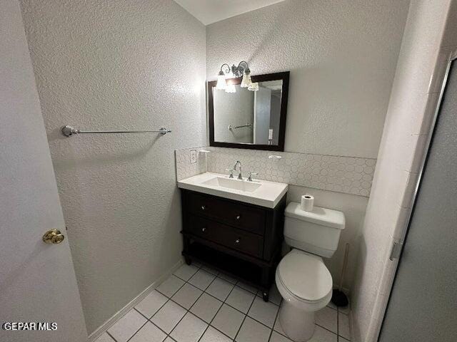 2129 Noviembre Dr, El Paso, TX 79935 - bathroom with tile patterned floors, vanity, a textured wall, and decorative backsplash