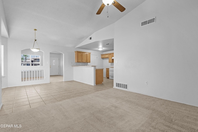 12920 Tierra Salas Dr, El Paso, TX 79938 - unfurnished living room featuring vaulted ceiling, arched walkways, a ceiling fan, light tile patterned floors, and light colored carpet