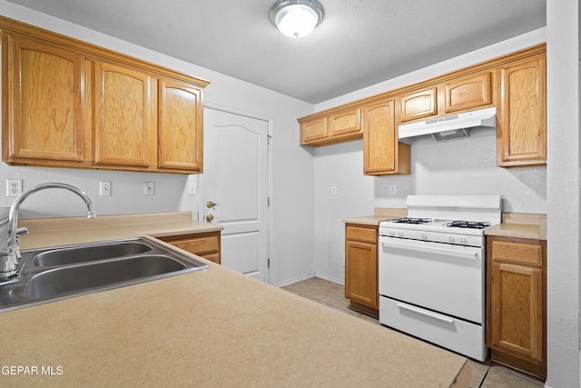 12920 Tierra Salas Dr, El Paso, TX 79938 - kitchen with white range with gas cooktop, under cabinet range hood, light tile patterned floors, and light countertops