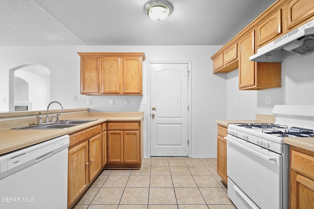 12920 Tierra Salas Dr, El Paso, TX 79938 - kitchen with white appliances, under cabinet range hood, arched walkways, light countertops, and light tile patterned flooring