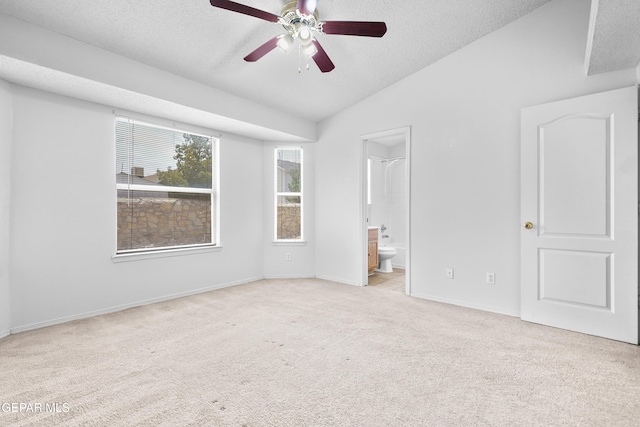 12920 Tierra Salas Dr, El Paso, TX 79938 - unfurnished bedroom featuring light carpet, vaulted ceiling, a textured ceiling, ensuite bath, and ceiling fan