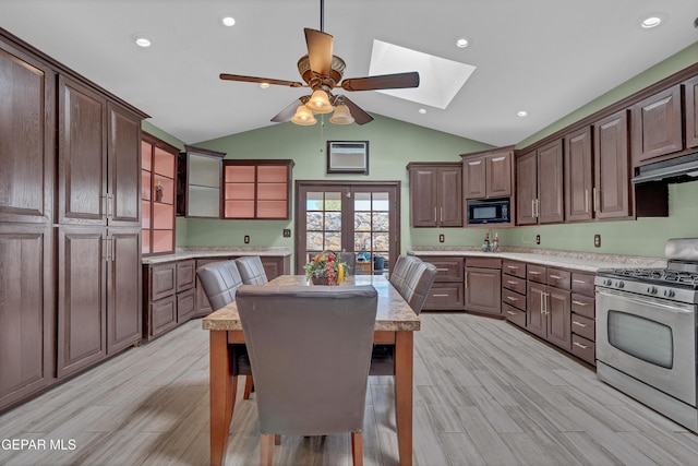 12249 Holy Springs Ct, El Paso, TX 79928 - kitchen with stainless steel range with gas stovetop, black microwave, a skylight, under cabinet range hood, and a ceiling fan