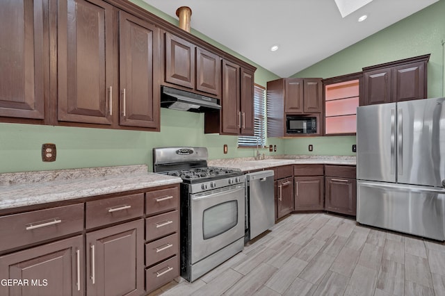 12249 Holy Springs Ct, El Paso, TX 79928 - kitchen with stainless steel appliances, under cabinet range hood, vaulted ceiling, a skylight, and recessed lighting