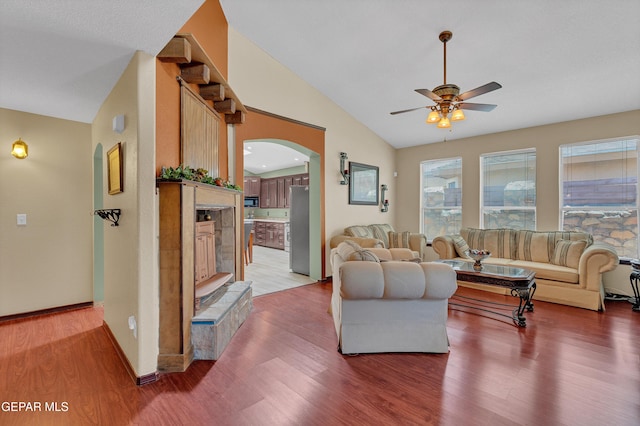 12249 Holy Springs Ct, El Paso, TX 79928 - living area with lofted ceiling, a ceiling fan, arched walkways, and light wood-style flooring