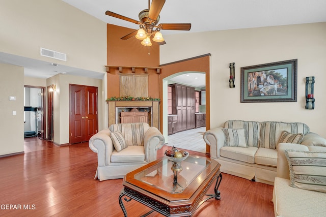 12249 Holy Springs Ct, El Paso, TX 79928 - living room featuring arched walkways, ceiling fan, wood finished floors, and high vaulted ceiling