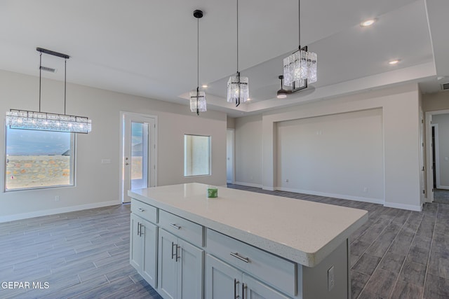 1798 Dana Gray St, El Paso, TX 79928 - kitchen featuring wood finished floors, light countertops, hanging light fixtures, open floor plan, and a center island