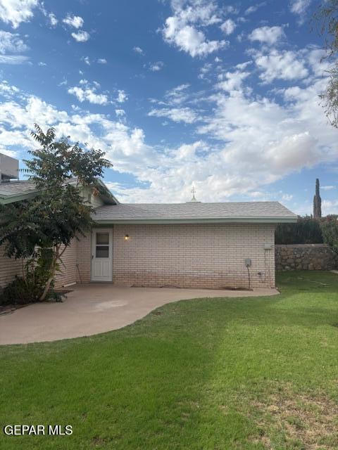 10700 Janway Dr, El Paso, TX 79935 - rear view of property with a patio area, a yard, and brick siding