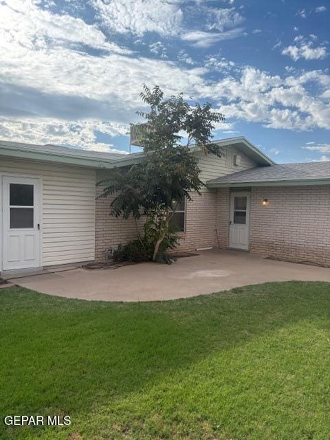 10700 Janway Dr, El Paso, TX 79935 - back of house with a patio area, a lawn, and brick siding