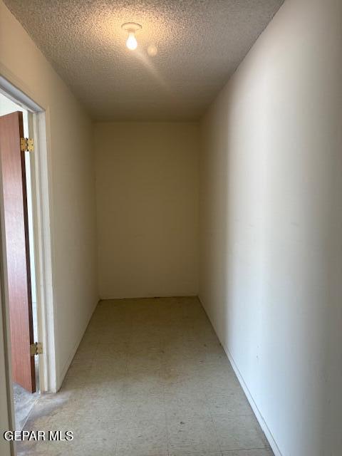 10700 Janway Dr, El Paso, TX 79935 - corridor with a textured ceiling and light floors