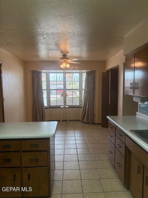 10700 Janway Dr, El Paso, TX 79935 - kitchen featuring a ceiling fan, a textured ceiling, light countertops, and light tile patterned flooring
