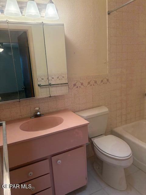 10700 Janway Dr, El Paso, TX 79935 - bathroom featuring vanity, tile walls, tile patterned floors, bathtub / shower combination, and wainscoting