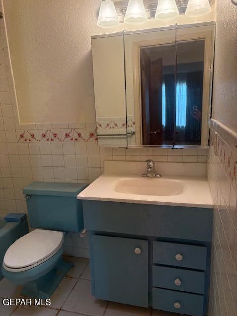10700 Janway Dr, El Paso, TX 79935 - full bathroom featuring tile walls, vanity, tile patterned floors, and wainscoting