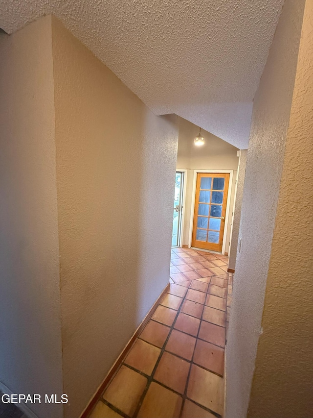 12304 Bill Mitchell Dr, El Paso, TX 79938 - corridor with a textured wall, a textured ceiling, tile patterned flooring, and lofted ceiling