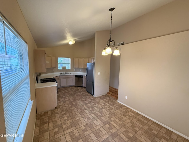 12304 Bill Mitchell Dr, El Paso, TX 79938 - kitchen with stainless steel dishwasher, freestanding refrigerator, light countertops, vaulted ceiling, and decorative light fixtures