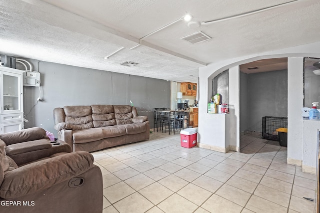 204 Ruth St, Anthony, NM 88021 - living room with light tile patterned flooring, arched walkways, and a textured ceiling