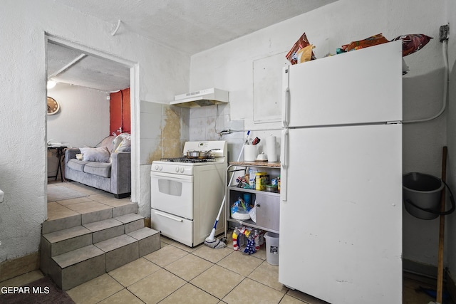 204 Ruth St, Anthony, NM 88021 - kitchen with white appliances, range hood, light tile patterned flooring, and a textured ceiling