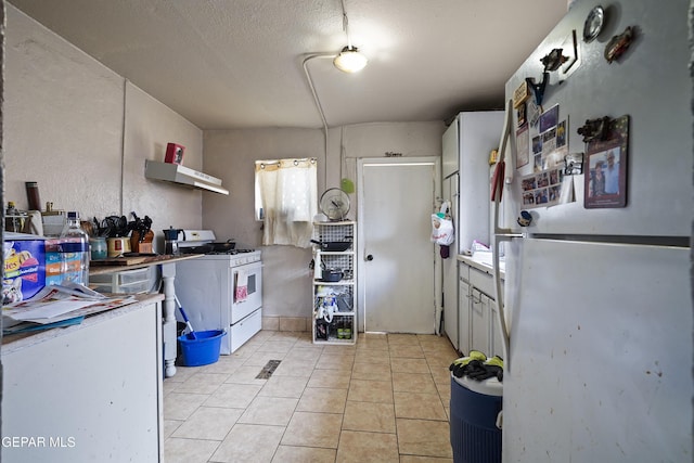 204 Ruth St, Anthony, NM 88021 - kitchen featuring white appliances, exhaust hood, light tile patterned flooring, and a textured ceiling
