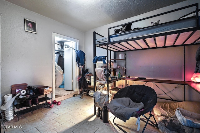 204 Ruth St, Anthony, NM 88021 - tiled bedroom featuring a textured ceiling and a textured wall