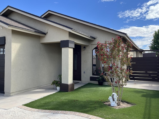 11128 Colbert Coldwell Ln, Socorro, TX 79927 - doorway to property with stucco siding and a lawn