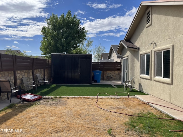 11128 Colbert Coldwell Ln, Socorro, TX 79927 - fenced backyard featuring a storage unit and a patio area
