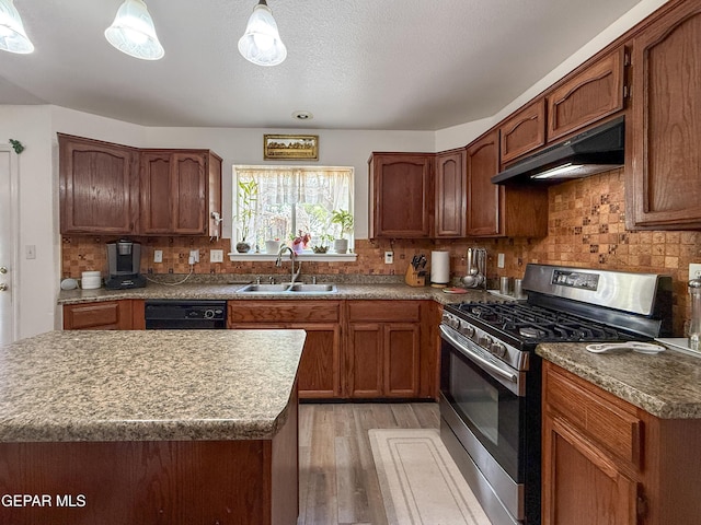 14177 Spanish Point Dr, El Paso, TX 79938 - kitchen with stainless steel range with gas stovetop, under cabinet range hood, light wood-type flooring, tasteful backsplash, and dishwasher