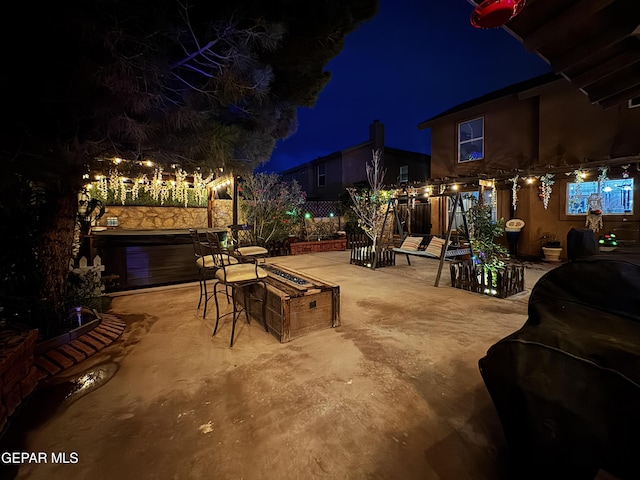 14177 Spanish Point Dr, El Paso, TX 79938 - patio at night featuring a patio, area for grilling, a fire pit, and a hot tub