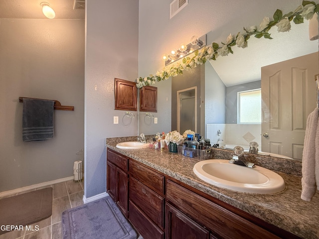 14177 Spanish Point Dr, El Paso, TX 79938 - full bath featuring double vanity, radiator, lofted ceiling, and tile patterned floors