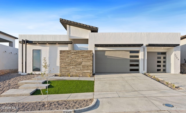 7349 Cimarron Rim Dr, El Paso, TX 79911 - modern home with concrete driveway, a garage, stucco siding, and stone siding