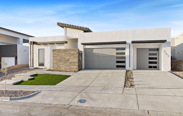 7349 Cimarron Rim Dr, El Paso, TX 79911 - contemporary house featuring a garage, driveway, stucco siding, and stone siding