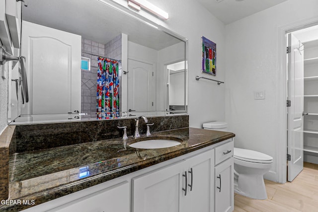 6528 Calle Placido Dr, El Paso, TX 79912 - bathroom with vanity, a shower with shower curtain, a spacious closet, and wood finished floors