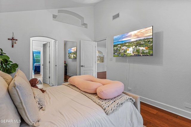 6528 Calle Placido Dr, El Paso, TX 79912 - bedroom with arched walkways, high vaulted ceiling, wood finished floors, and ensuite bath