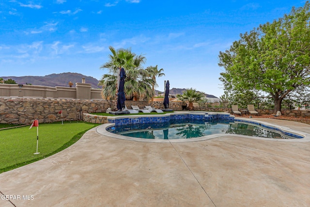 6528 Calle Placido Dr, El Paso, TX 79912 - view of pool with a patio area, a mountain view, an area to practice putting, and a fenced backyard