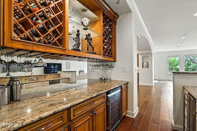 6528 Calle Placido Dr, El Paso, TX 79912 - indoor bar featuring wine cooler, dark wood-style floors, arched walkways, recessed lighting, and ornamental molding
