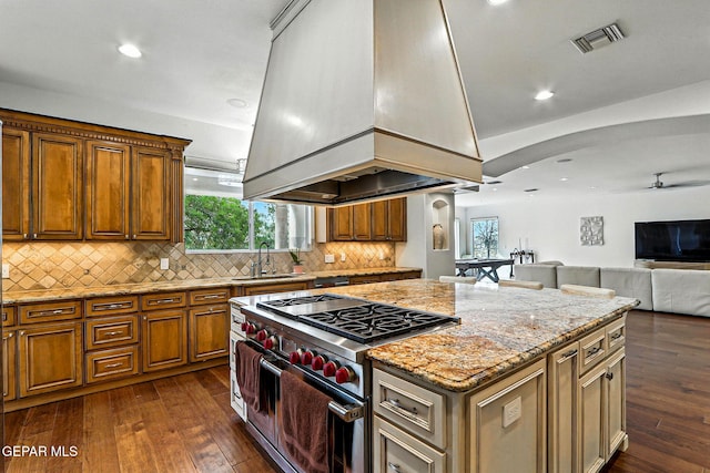 6528 Calle Placido Dr, El Paso, TX 79912 - kitchen with range with two ovens, custom range hood, a center island, dark wood-style floors, and light stone countertops
